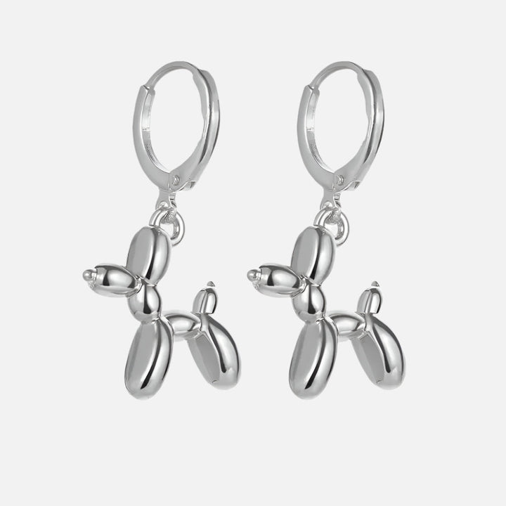 Gold Huggie earrings with a mini balloon-shaped dog pendant