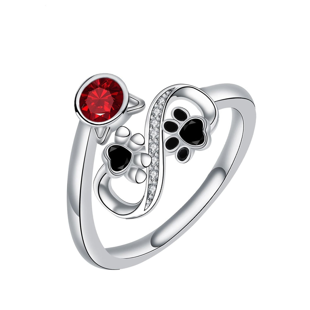 Adjustable ring with black paw print and red gemstones