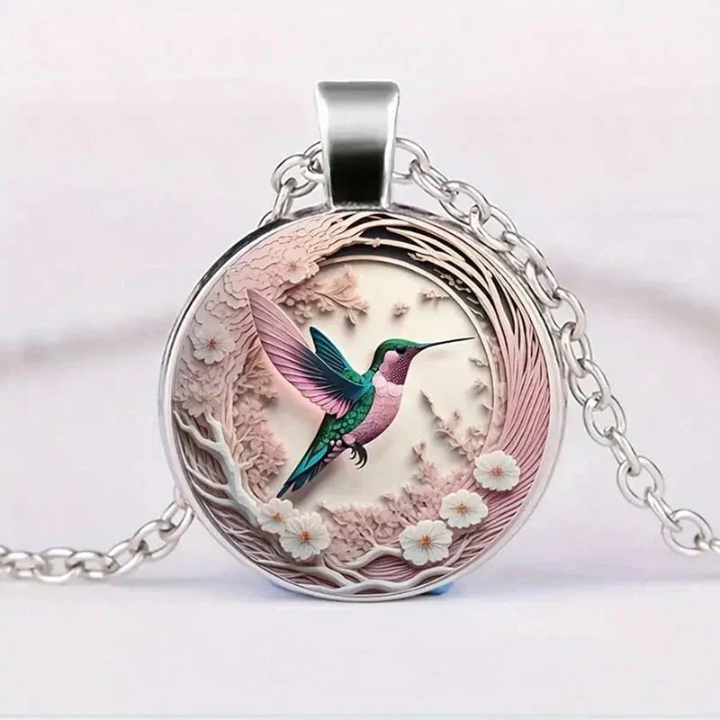 Necklace with glass dome pendant featuring a hummingbird